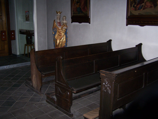 Bänke und Figur, die  nicht in die Kirche passen